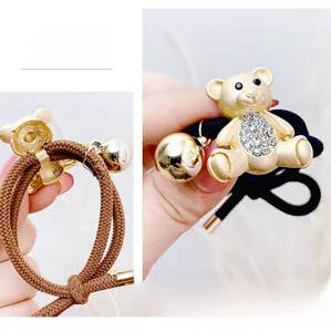 Detail of high-elasticity bear hair ties with golden metal charms and clear rhinestones