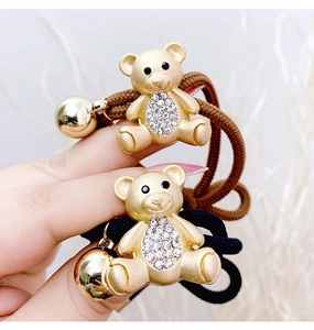 Detailed close-up of bear hair ties featuring gold matte texture and sparkling crystals