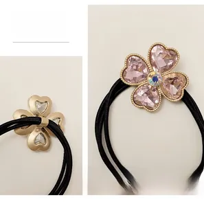 Dettaglio dell'elastico per capelli con fiore in cristallo rosa e base dorata