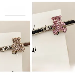 Close-up of sparkling rhinestone bear hair clips in champagne gold and pink finishes