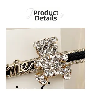 Detailed close-up of a rhinestone bear hair clip with me letter and woven texture