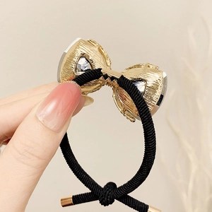 Elegant black elastic hair tie with a gold metal bow and sparkling crystals for women