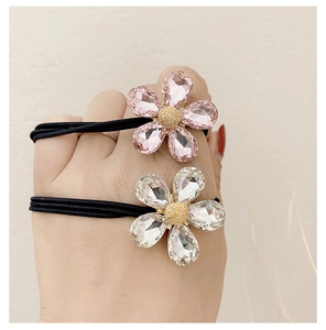 Dettaglio dell'elastico per capelli con fiore di cristallo rosa e petali di strass lucidi