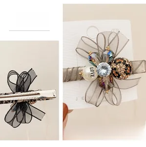 Detail of organza bow hair clip with rhinestones, pearls and leopard print accents