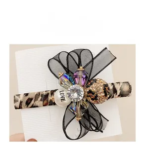 Detail of leopard print hair clip with black organza bow and rhinestone embellishments