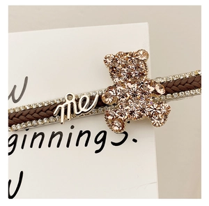 Macro detail of bear hair clip with champagne rhinestones and woven texture