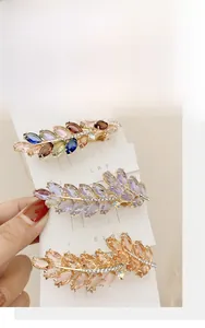 Detailed view of three wheat-ear spring hair clips featuring colorful rhinestone leaves