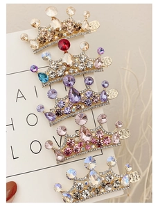 Dettaglio di fermagli a corona con strass colorati su scheda di supporto