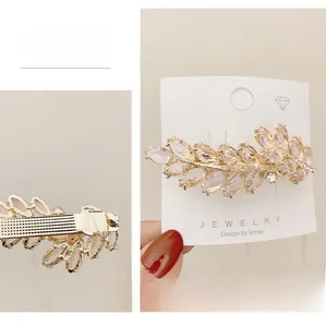 Detail of pink crystal wheat ear hair clip with golden alloy spring clamp back