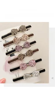 Détail de barrettes tissées avec des accents de papillons en strass scintillants