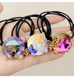 Detailed view of three cat-shaped crystal hair ties with sparkling rhinestones and gold accents