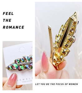 Detailed macro view of gold alloy leaf hair clip with purple and green crystals