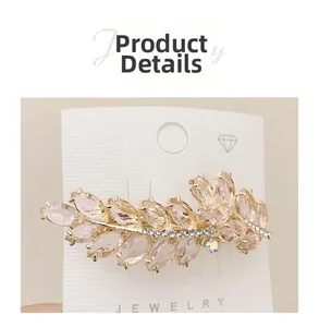 Detailed view of pink crystal wheat ear hair clip with rhinestones on gold base