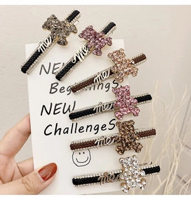 Detail of 6 colorful rhinestone bear hair clips with woven texture and me lettering