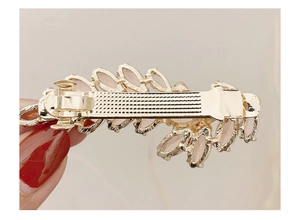 Detail view of the spring clip back mechanism on the wheat ear hair accessory