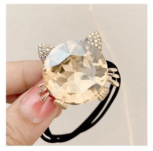 Close-up of cute cat hair tie with champagne crystal stone and gold rhinestones details