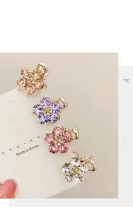 Detailed macro view of four mini floral hair clips with sparkling colorful rhinestones