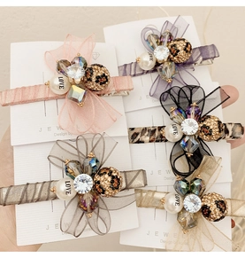 Detailed view of organza bow hair clips with rhinestones and LOVE pearl accents