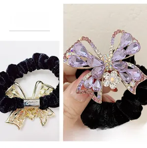 Dettaglio di elastico in velluto nero con farfalla di cristallo e gemme viola