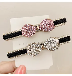 Détail de pinces à cheveux nśud en strass rose et argent avec base tressée et cristaux fins