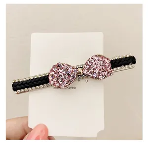 Gros plan d'une pince à cheveux tressée avec strass et nœuds en cristal rose