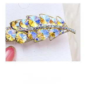 Detailed macro view of leaf-shaped hair clip with iridescent AB crystals on gold alloy