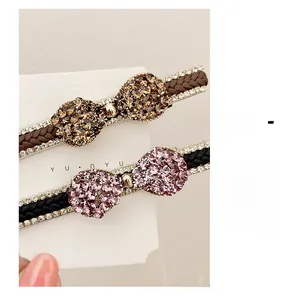 Détail de barrettes à nœud en cristal avec tissage strass et clip bec de canard en métal