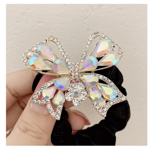Dettaglio scrunchie in velluto con farfalla di strass e gemme colorate luccicanti