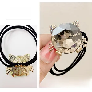 Detail showing front and back of cat-shaped hair tie with brown crystal and rhinestones