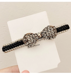 Macro de la pince à cheveux noeud en strass argentés avec corde tressée noire et perle