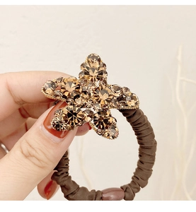 Détail d'un chouchou étoile de mer avec strass ambrés sur élastique plissé marron