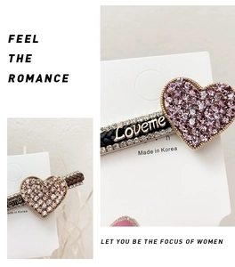 Close-up of heart-shaped rhinestone hair clips with Loveme metal lettering on display card