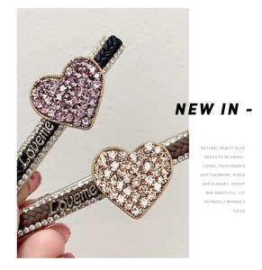 Close-up of heart-shaped rhinestone hair clips with braided texture and Loveme metal logo