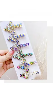Detail of crystal butterfly hair clips in multiple colors with golden alloy finish