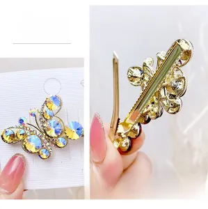 Detail of crystal butterfly hair clip with gold alloy duckbill closure and purple rhinestones