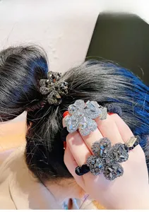 Dettaglio di elastici per capelli ad alta elasticità con trifoglio di strass e finitura metallica