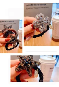 Dettaglio di ciondoli a quadrifoglio e stella con strass su elastici per capelli neri