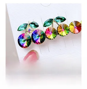 Close-up of a sparkling crystal cherry hair clip with green leaves and gold finish