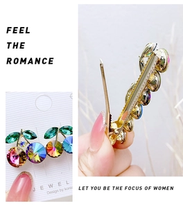 Detail of cherry-shaped gold clip with colorful rhinestones and secure back structure