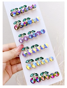 Detail view of crystal cherry hair clips with colorful rhinestones and leaf accents