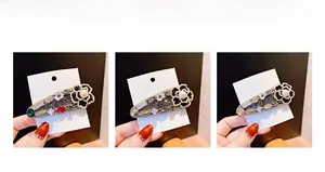 Vue détaillée d'une barrette fleur camélia en forme de goutte avec perles et strass
