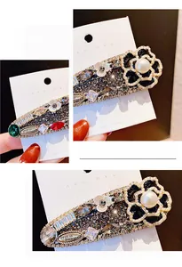Détail macro d'une pince à cheveux camélia avec strass brillants et centre perlé