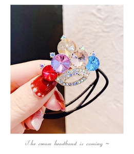 Dettaglio di elastico per capelli a corona con cristalli colorati e strass scintillanti