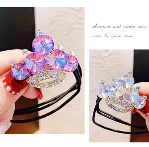 Dettaglio di un elastico per capelli a corona con cristalli viola e brillantini