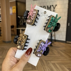 Detailed view of handmade baroque hair clips with knitted rabbits and gemstones