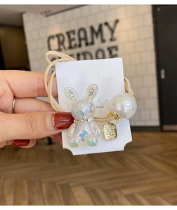 Close-up of iridescent rabbit hair tie with large pearl and double elastic band