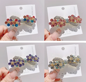 Detail of four crystal bow hair clips with colorful rhinestones in a grid display