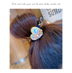 Detail of vintage heart hair tie with pearls and crystals on a braided hairstyle