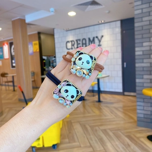 Détail d'élastiques à cheveux panda avec des strass colorés et des bandes élastiques