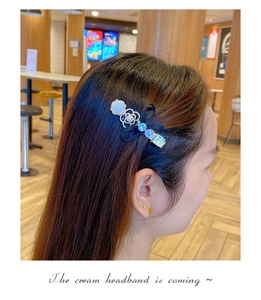 Detail view of bow hair clip with camellia pearl and rhinestone on a female model